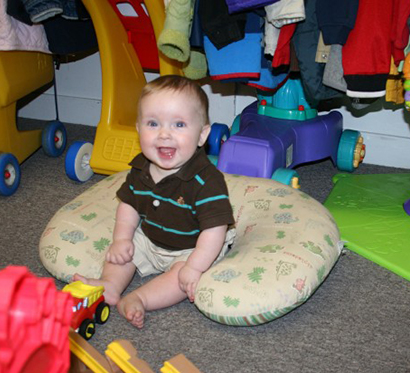A baby boy smiling while playing at Kid Stuff